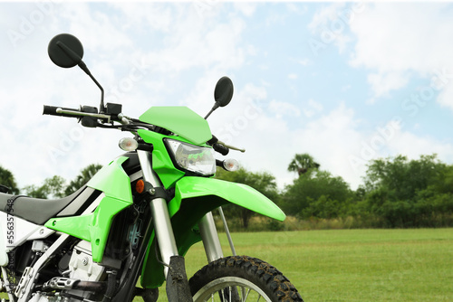 Stylish green cross motorcycle outdoors, space for text