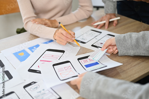 A team of mobile app developers discussing on their new mobile app interface design. cropped