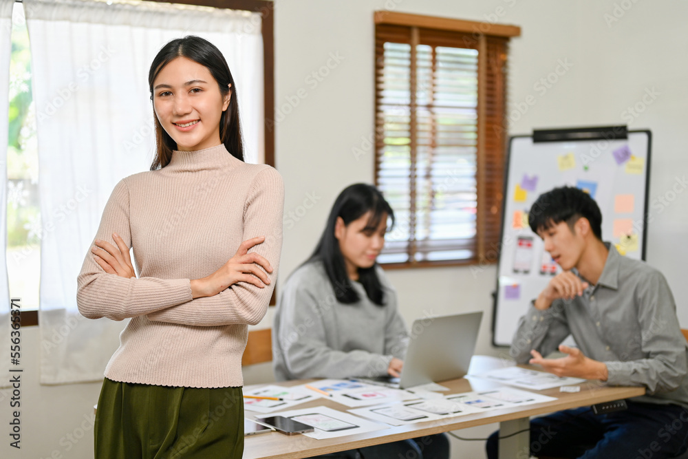 Successful Asian female boss stands with her arms crossed, in front of the meeting room Successful Asian female boss stands with her arms crossed, in front of the meeting room