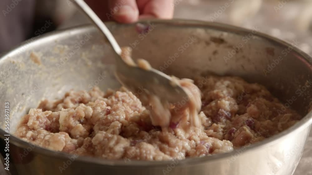 Mixing raw minced pork in a bowl with spicies Mixing raw minced pork in a bowl with spicies