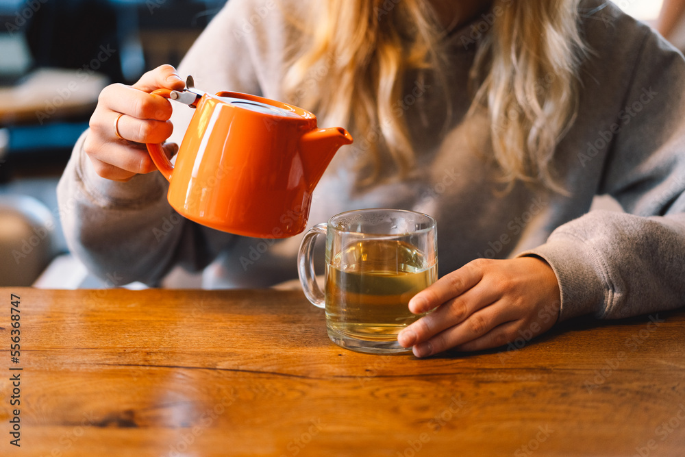 Portrait of a joyful teengirl enjoying a cup of tea at cafe. Smiling beautiful girl drinks hot tea in winter. Teengirl drinking hot tea. Cafe city lifestyle. Colorful portrait of happy pretty girl Portrait of a joyful teengirl enjoying a cup of tea at cafe. Smiling beautiful girl drinks hot tea in winter. Teengirl drinking hot tea. Cafe city lifestyle. Colorful portrait of happy pretty girl