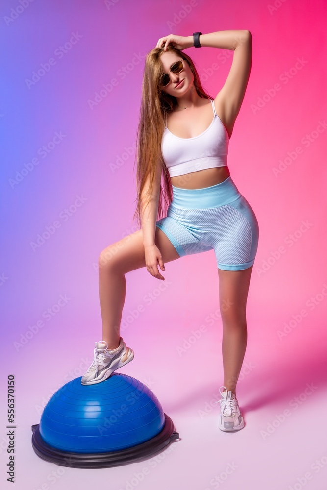 Slim woman in sportswear touching hair and looking at camera Slim woman in sportswear touching hair and looking at camera