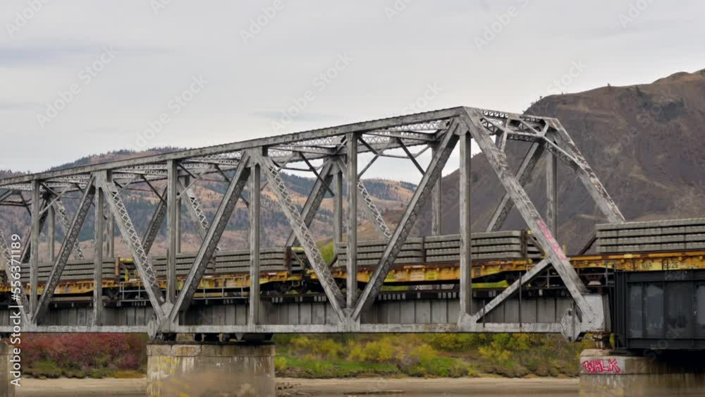 a freight Train crossing the South Thompson River via the CNR Bridge close to Riverside Park East of Downtown Kamloops on an overcast day in autumn a freight Train crossing the South Thompson River via the CNR Bridge close to Riverside Park East of Downtown Kamloops on an overcast day in autumn