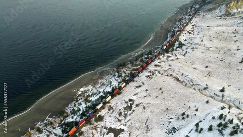 A colorful train rides along Kamloops Lake's sandy beaches in the snow 
A beautiful view of the Nicola Thompson Region in Canada's Okanagan with its hilly desert terrain and light water waves photo