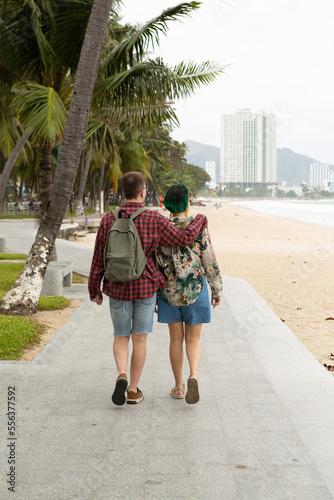 young guy hugs a girl and walk along the promenade