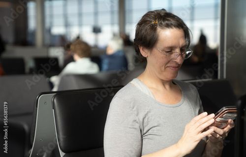 Woman at an airport waiting for flight working on her phone