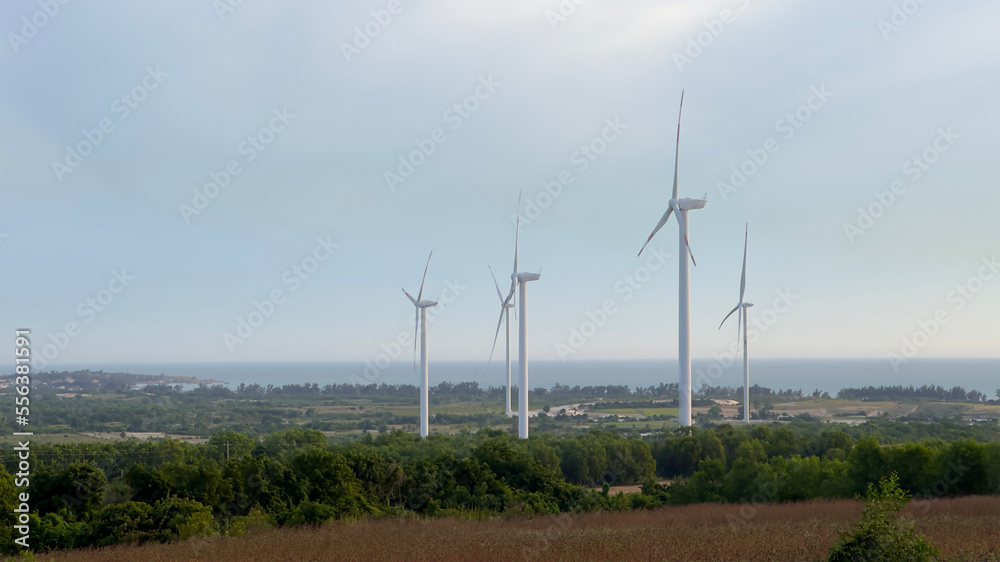 Windmills for electric power production in Vietnam. Wind turbines farm, windmill farm producing green energy on natural background. Renewable Energy concept, technology landscape 