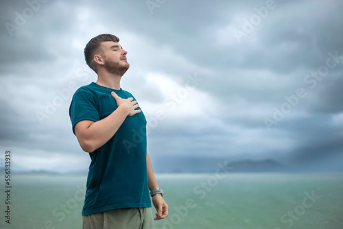 Fényképezés happy handsome free guy, young calm relaxed carefree man traveler with open raised hands enjoy sea, ocean view, person feeling good, breath deep deeply fresh air