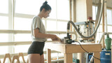 girl carpenter polishing a wooden blank on a grinder