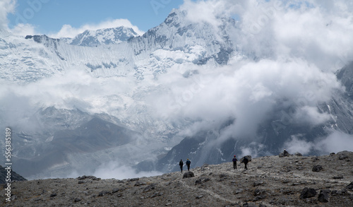 tourists walk in the Himalayas against the backdrop of Mount Amadablam
