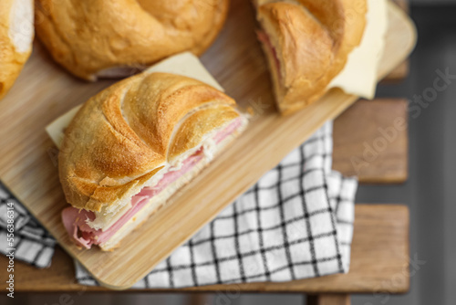 Tableau sur toile Delicious kaiser rolls with ham and cheese on table