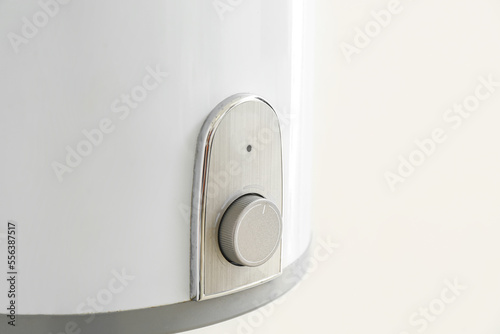 Modern electric boiler on white wall, closeup