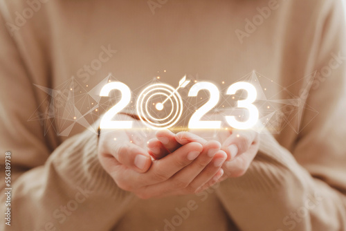 Women holding virtual 2023 numbers with white dartboards for merry Christmas and happy new year, Setup new business objective target concept. Beginning of New Year 2023. photo