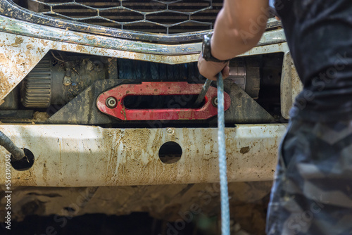 Man use Winch Device at Front of Pick up Off Road Vehicle. Man use the winch helps to drag the car when stuck.