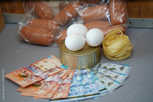 Almaty, Kazakhstan - 10.04.2022 : Various food products and banknotes of Kazakhstani tenge are laid out on the table. photo