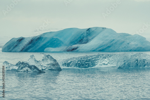 Floating ice pieces in ocean landscape photo. Beautiful nature scenery photography with fog on background. Idyllic scene. High quality picture for wallpaper, travel blog, magazine, article