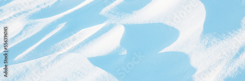 Snow texture. Wind sculpted patterns on snow surface. Wind in the tundra and in the mountains on the surface of the snow sculpts patterns and ridges (sastrugi). Arctic, Polar region. Winter background photo