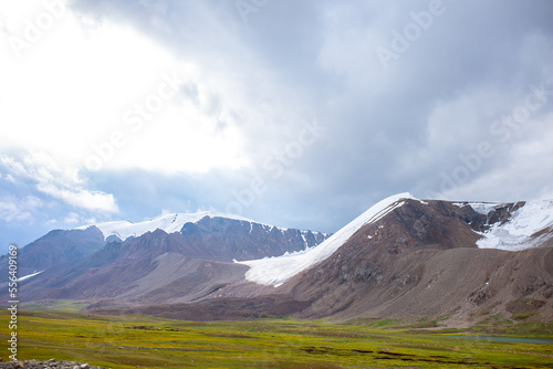 Beautiful nature of rocky mountains and peaks with glaciers. Unusual landscape of nature. Rocks on the background of the sky with clouds. Bad weather cyclone, rainy season, foggy day.