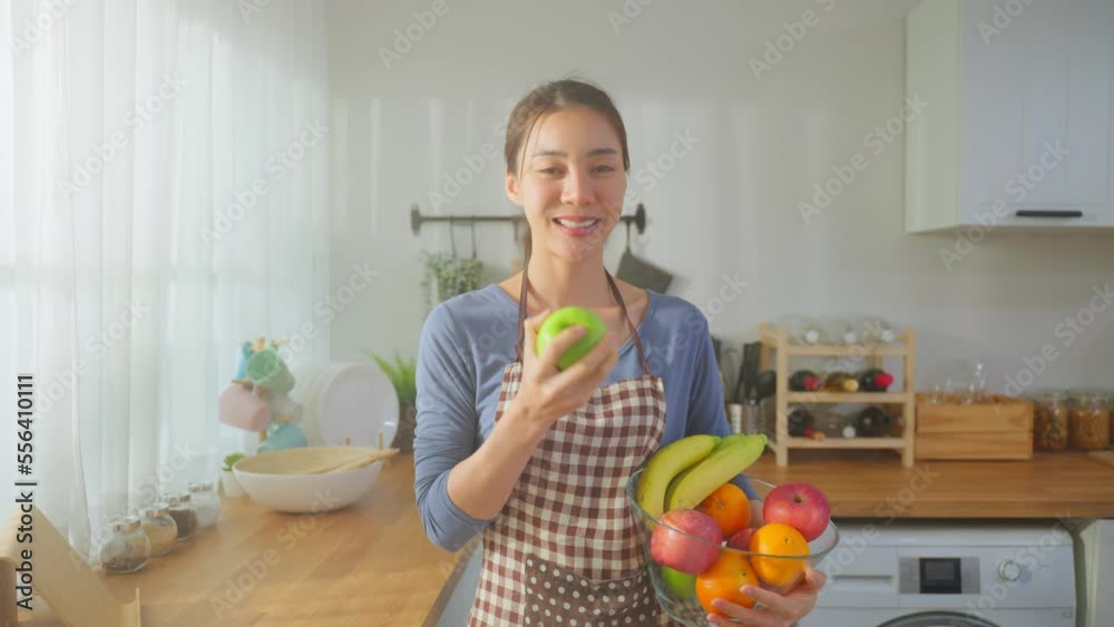 Portrait of Asian young woman hold a bowl of fruits and look at camera. Portrait of Asian young woman hold a bowl of fruits and look at camera.