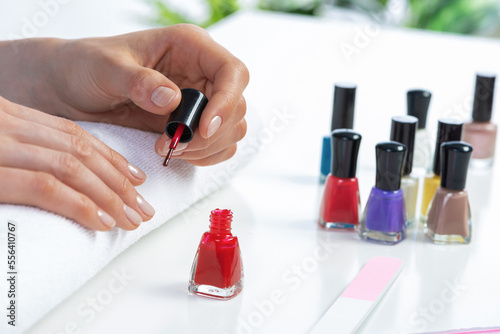 Woman giving herself elegant manicure at home