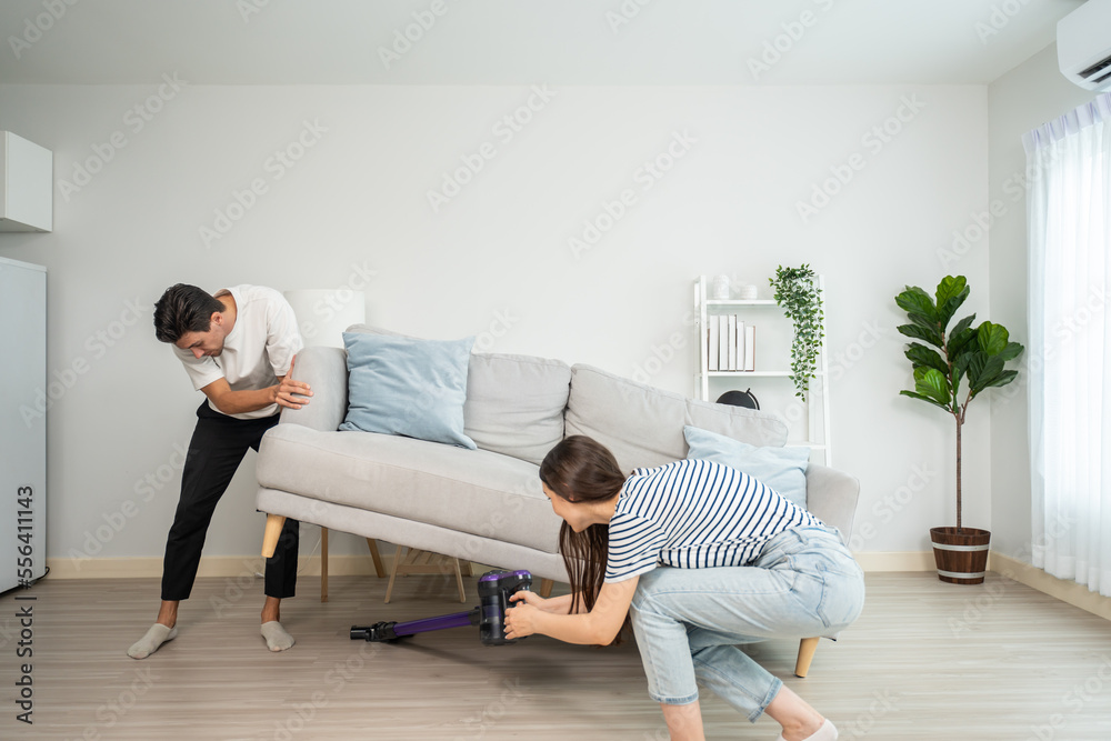 Caucasian young loving couple decorate living room at home together. 