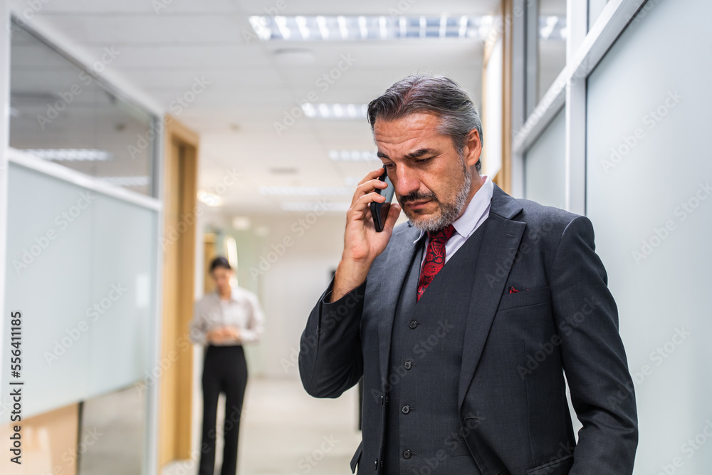 Caucasian businessman talk on phone and walking in corridor of office. Caucasian businessman talk on phone and walking in corridor of office.