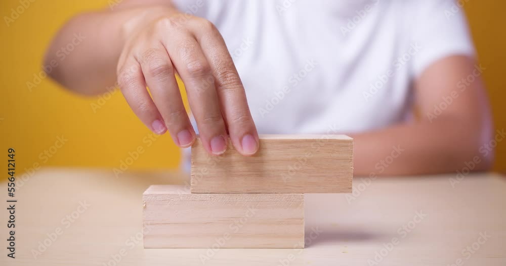 Hand putting wood cubes on top of wood block stacking as step stair business growth to success but it failed. The concept for management plan strategy. Hand putting wood cubes on top of wood block stacking as step stair business growth to success but it failed. The concept for management plan strategy.