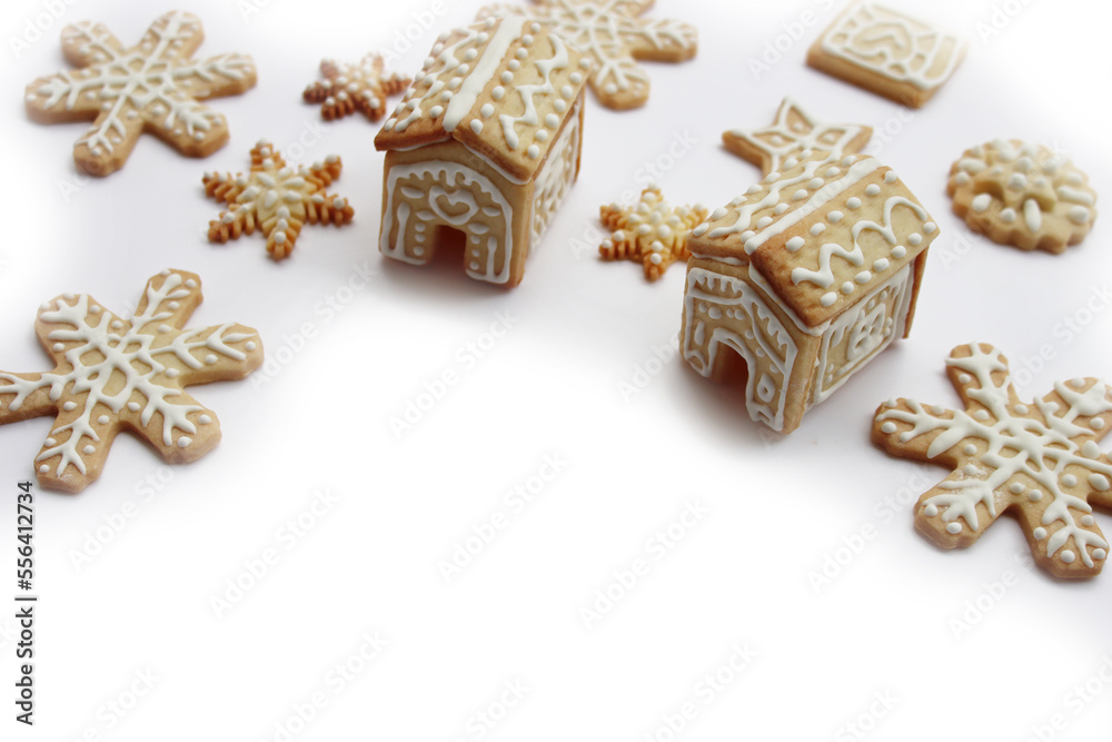 Small Gingerbread houses with many gingerbread cookies in shape of stars and snowflake isolated on white background with copy space Small Gingerbread houses with many gingerbread cookies in shape of stars and snowflake isolated on white background with copy space