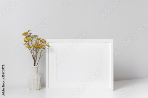 Landscape frame mockup in white minimalistic interior with dry flowers in vase