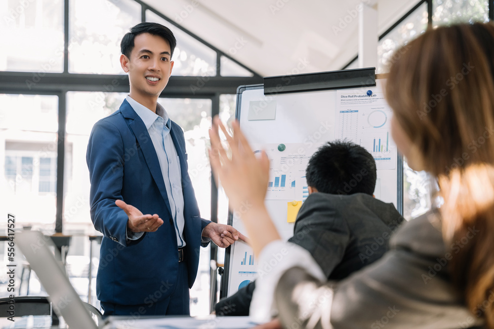 Asian businessman showing hand and smiling young team of colleagues making good business discussion in modern coworking office concept teamwork people. Asian businessman showing hand and smiling young team of colleagues making good business discussion in modern coworking office concept teamwork people.
