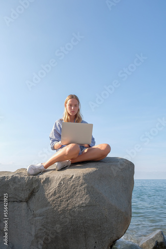 Remote work.Girl freelancer works remotely on the sea shore. workation, remote work,WFVH,Van Life vibes work from vacation home,work travel,remotely work.Travelling.Work from vacation remotely