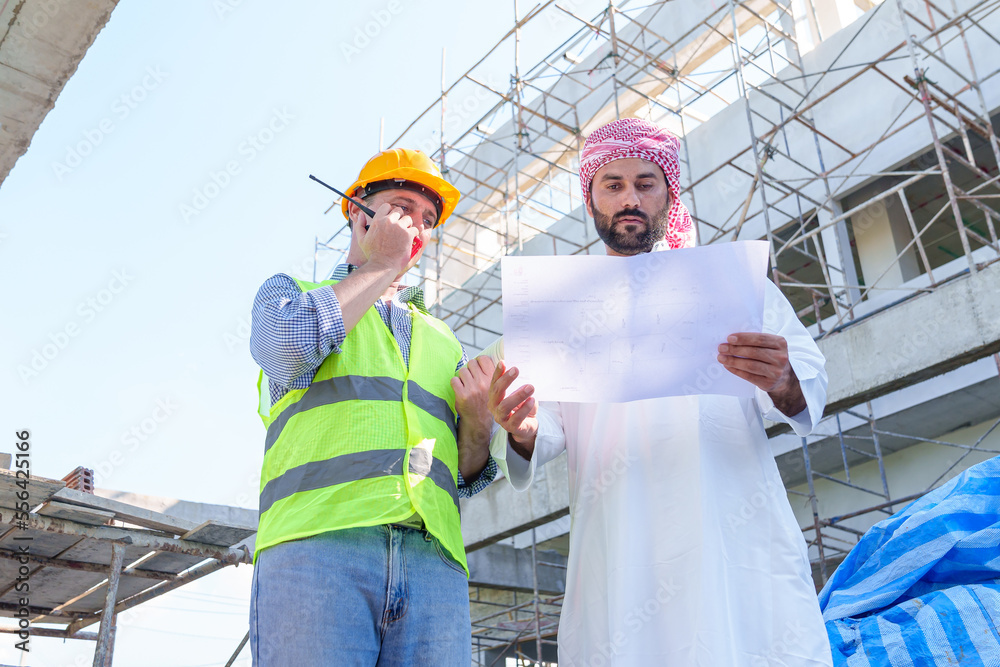 Arabic businessman teammates working together, construction engineer architect and worker looking building model and blueprint blueprint plans of Arab businessman. Arabic businessman teammates working together, construction engineer architect and worker looking building model and blueprint blueprint plans of Arab businessman.