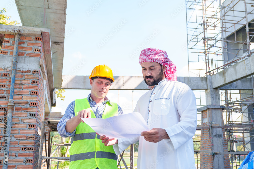 Arabic businessman teammates working together, construction engineer architect and worker looking building model and blueprint blueprint plans of Arab businessman. Arabic businessman teammates working together, construction engineer architect and worker looking building model and blueprint blueprint plans of Arab businessman.