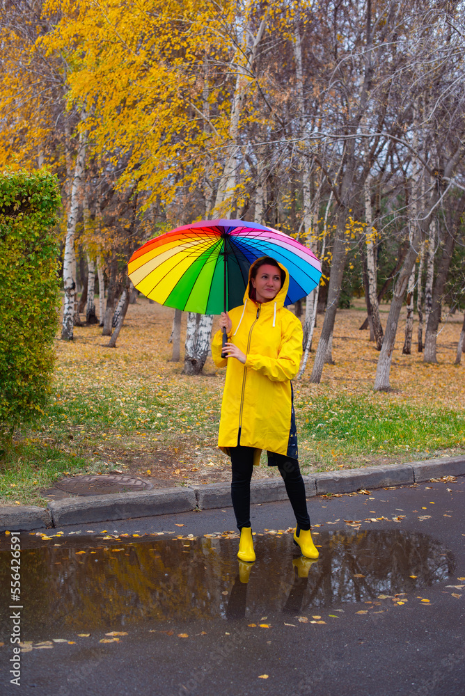 Obraz premium a girl under an umbrella in the rain walks in the park