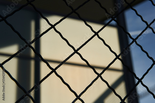 wire mesh metal fence on backlit background