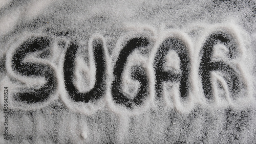 Palabra SUGAR escrita en un fondo de azúcar