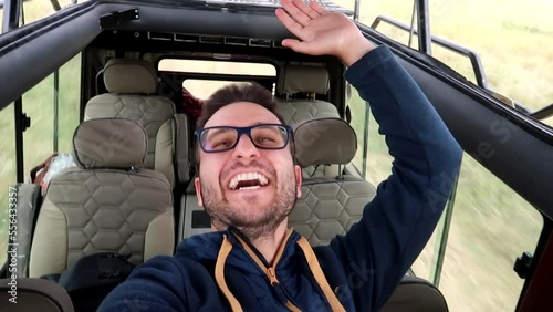 Slowmotion selfie shot of a man enjoying himself on a safari 4x4 in Tanzania photo