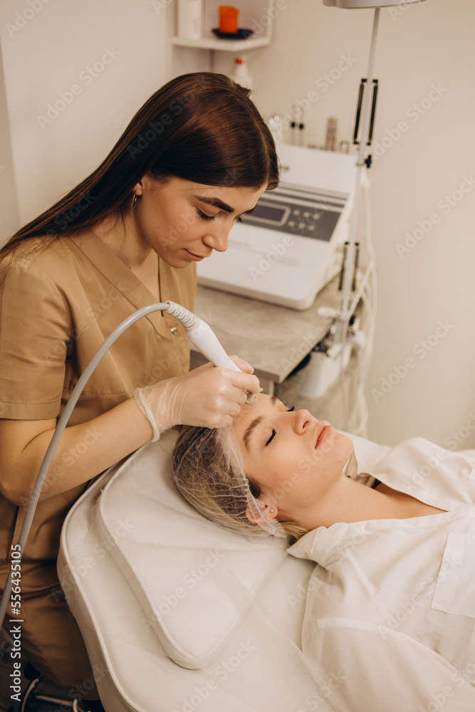 Fototapeta premium Face Skin Care. Close-up Of Woman Getting Facial Hydro Microdermabrasion Peeling Treatment At Cosmetic Beauty Spa Clinic. Hydra Vacuum Cleaner. Exfoliation, Rejuvenation And Hydratation. Cosmetology.