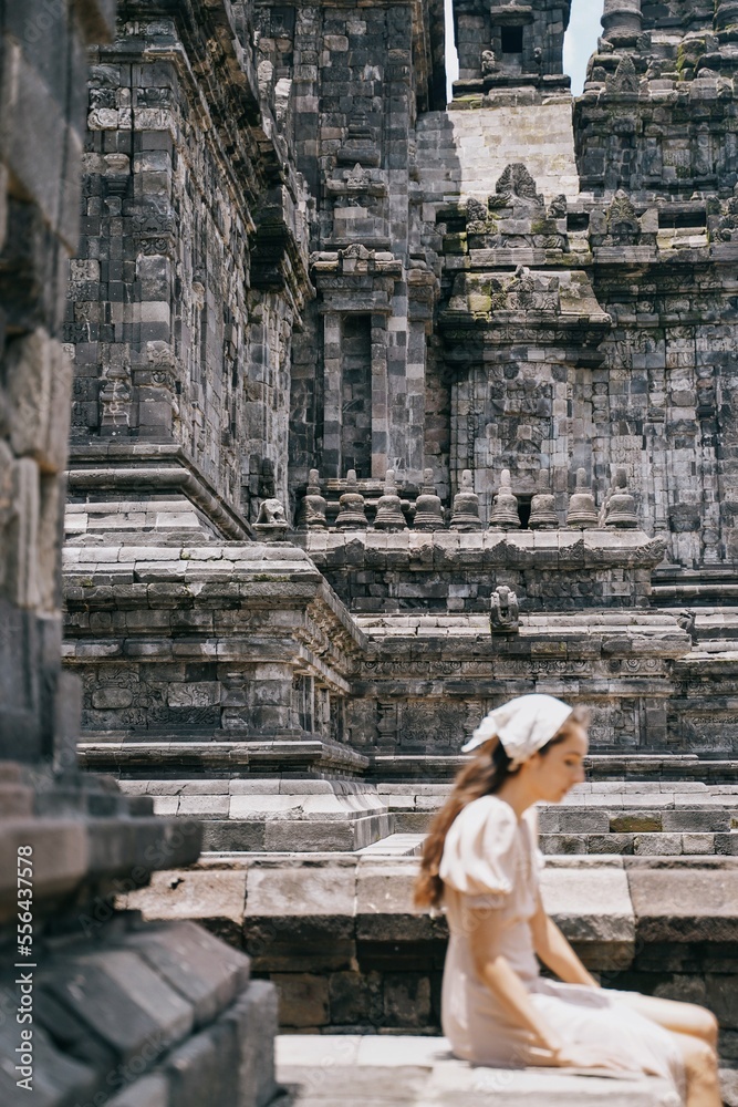 vertical tourist girl posing at prambanan temple, yogyakarta indonesia.