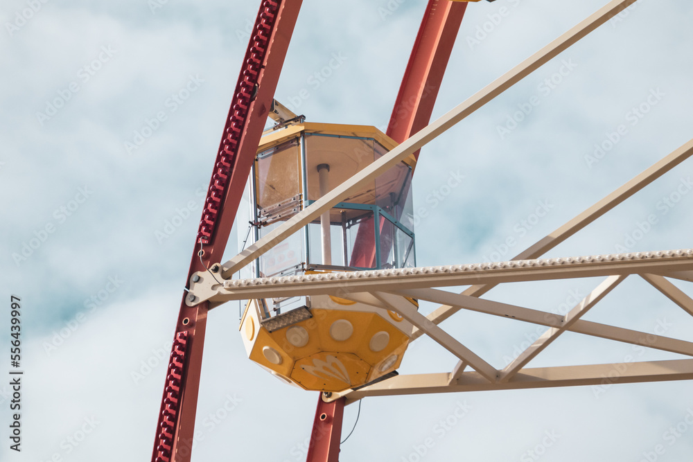 Yellow ferris wheel cabin close view on cloudy sky. Culture and recreation Central park, Kharkiv city. Amusement attraction details Yellow ferris wheel cabin close view on cloudy sky. Culture and recreation Central park, Kharkiv city. Amusement attraction details