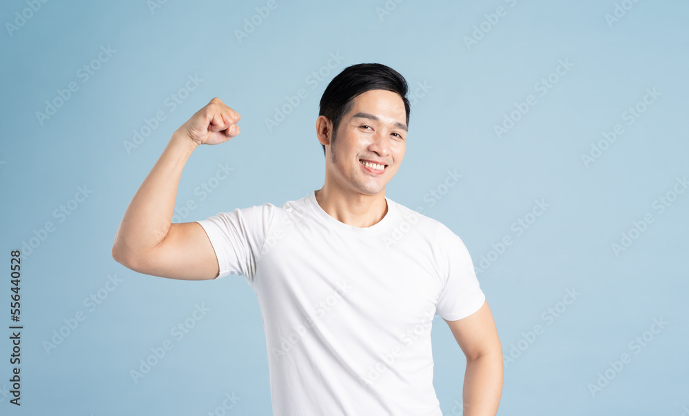 Asian male portrait posing on blue background Asian male portrait posing on blue background
