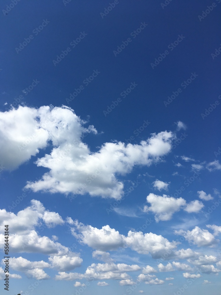 Bright blue sky filled with puffy white cumulus clouds, creating a peaceful and uplifting atmosphere, ideal for backgrounds, travel, and emphasizing positive emotions and natural beaut Bright blue sky filled with puffy white cumulus clouds, creating a peaceful and uplifting atmosphere, ideal for backgrounds, travel, and emphasizing positive emotions and natural beaut