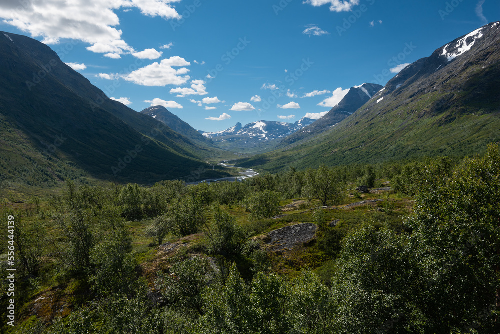 Scenic view on green valleys and mountain sides with snowy peaks along the scenic Sognefjellet road, Jotunheimen National Park, Norway Scenic view on green valleys and mountain sides with snowy peaks along the scenic Sognefjellet road, Jotunheimen National Park, Norway