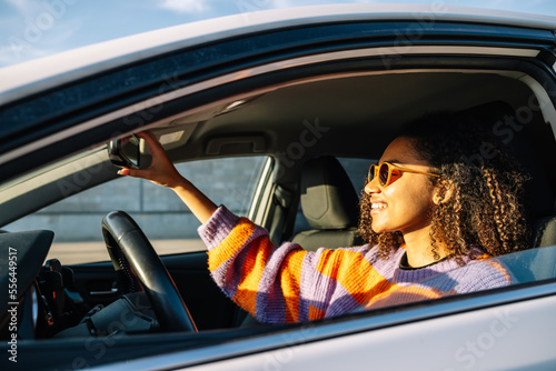 Wallpaper Mural Smiling ethnic woman in sunglasses driving car Torontodigital.ca