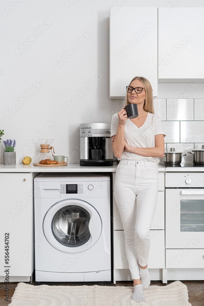 woman standing with mug and drink coffee at home kitchen woman standing with mug and drink coffee at home kitchen