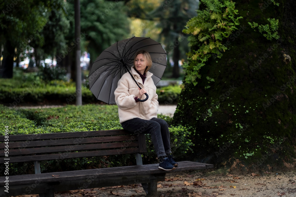 A woman with an umbrella in an autumn park.