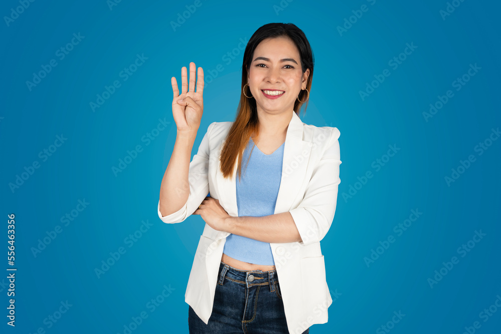 Pretty girl standing in a coat, holding her right hand and raising four left fingers Pretty girl standing in a coat, holding her right hand and raising four left fingers