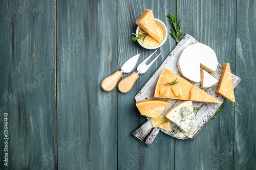 Parmesan. Cheeses set dor blu chedar camamber brie. Different types of cheese with knife on a wooden background. Long banner format. top view