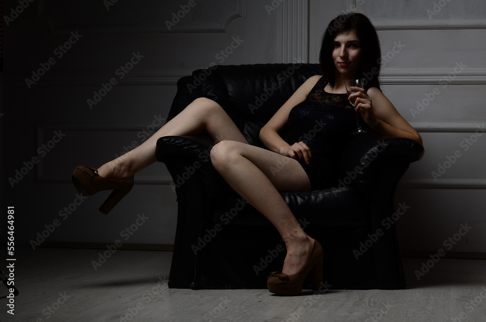 Sexy young brunette woman, wearing a mini black dress, in glamour full length, on gray background Sexy young brunette woman, wearing a mini black dress, in glamour full length, on gray background