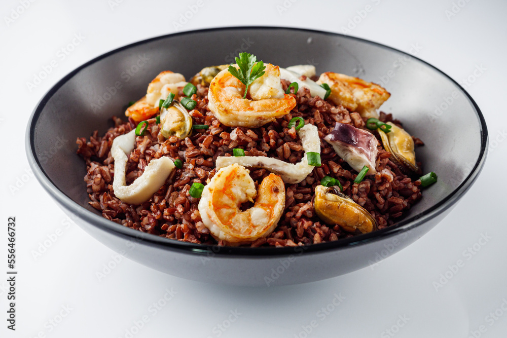 delicious red rice with shrimps and seafood on a white background